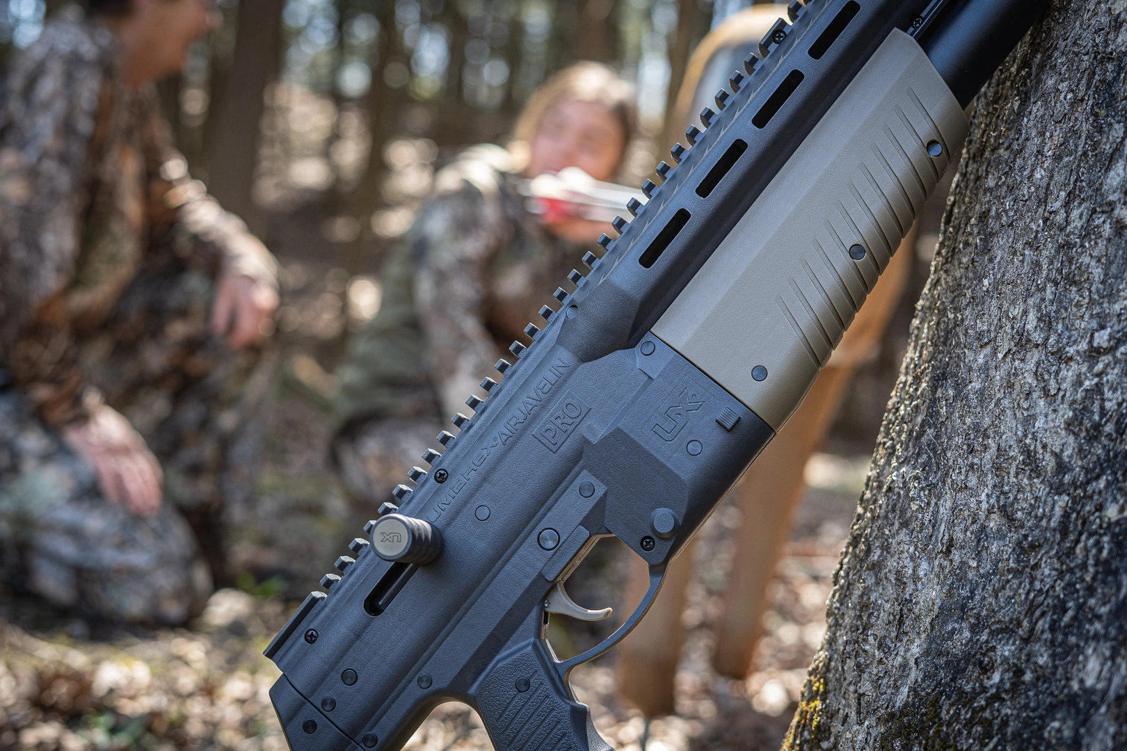 UMAREX AIRJAVELIN PRO LEANING ON A TREE IN THE WOODS